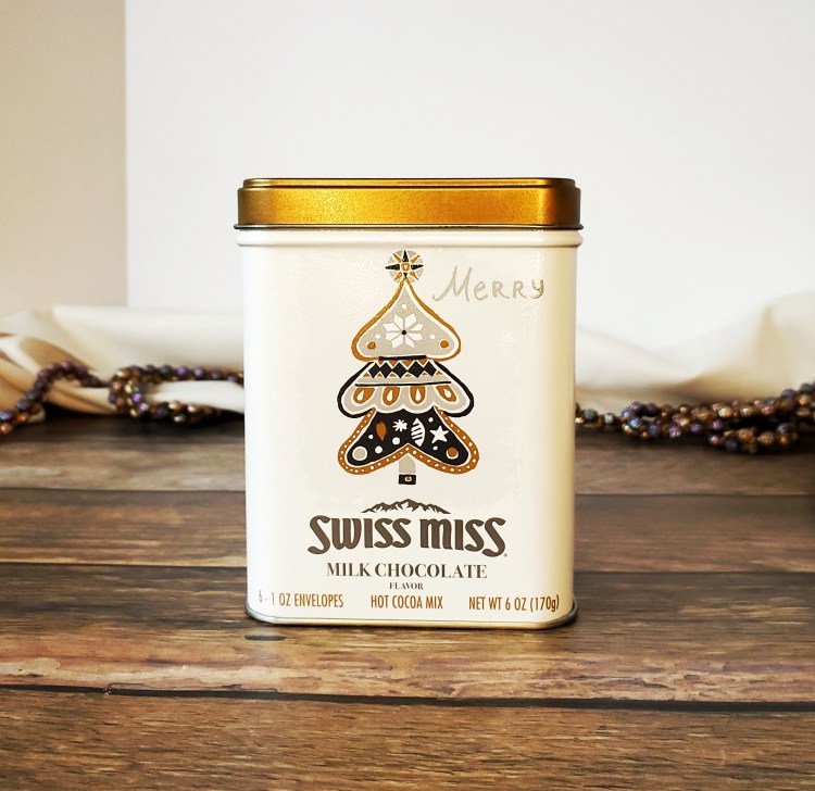 tin container that has a decorative tree with "Swiss Miss" on the side.