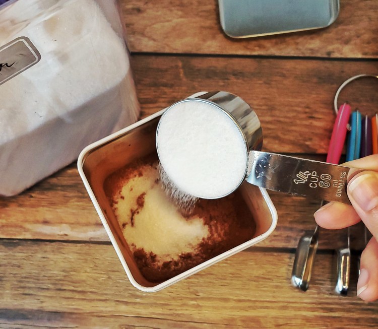 adding the sugar to the container