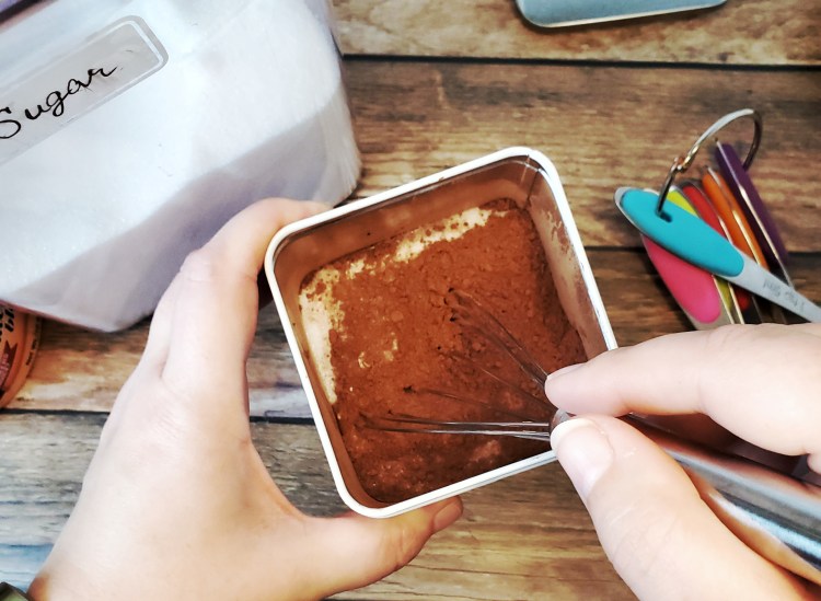 using a whisk to mix the cocoa in the container